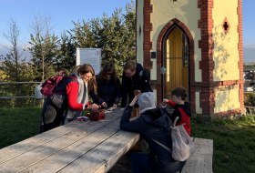 Gruppe von Menschen spielt vor Rotem Häuschen © We Escape